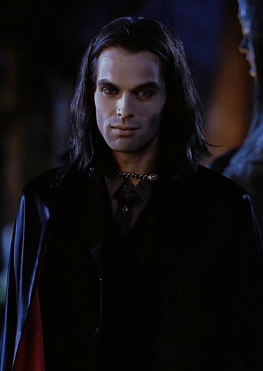 Picture of Dracula, dressed in black against a dark background